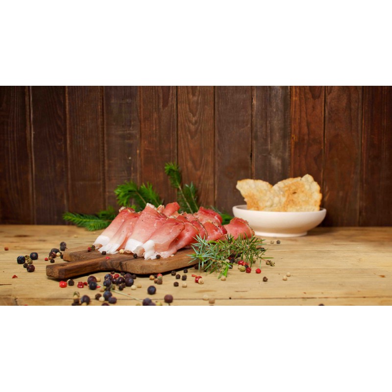 Fette di speck su tagliere in legno