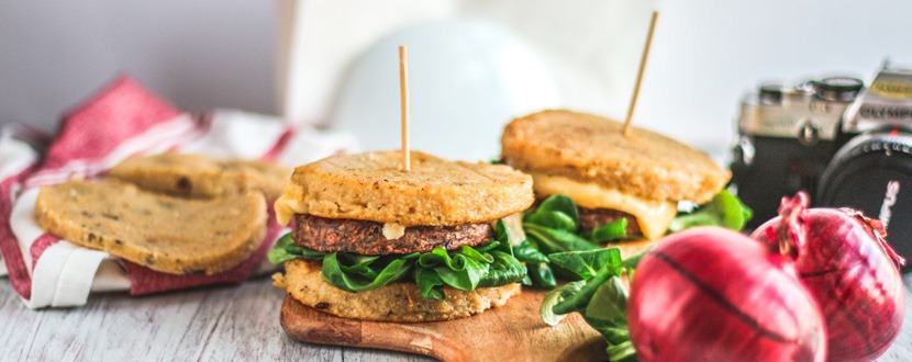 Burger di polenta con formaggio di montagna, cipolla caramellata e valeriana